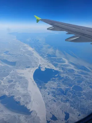 Взгляд от окна крыла самолета над морем и землей на яркий солнечный день  Стоковое Фото - изображение насчитывающей стратосфера, высоко: 127633566
