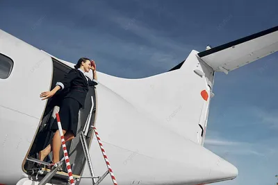Портрет красивой девушки-стюардессы на фоне пальм самолета | Премиум Фото