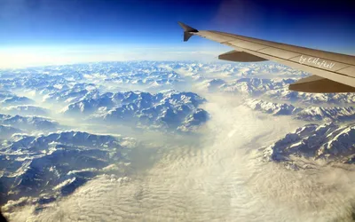 Вид из окна самолёта. Облака. Земля. Photos | Adobe Stock